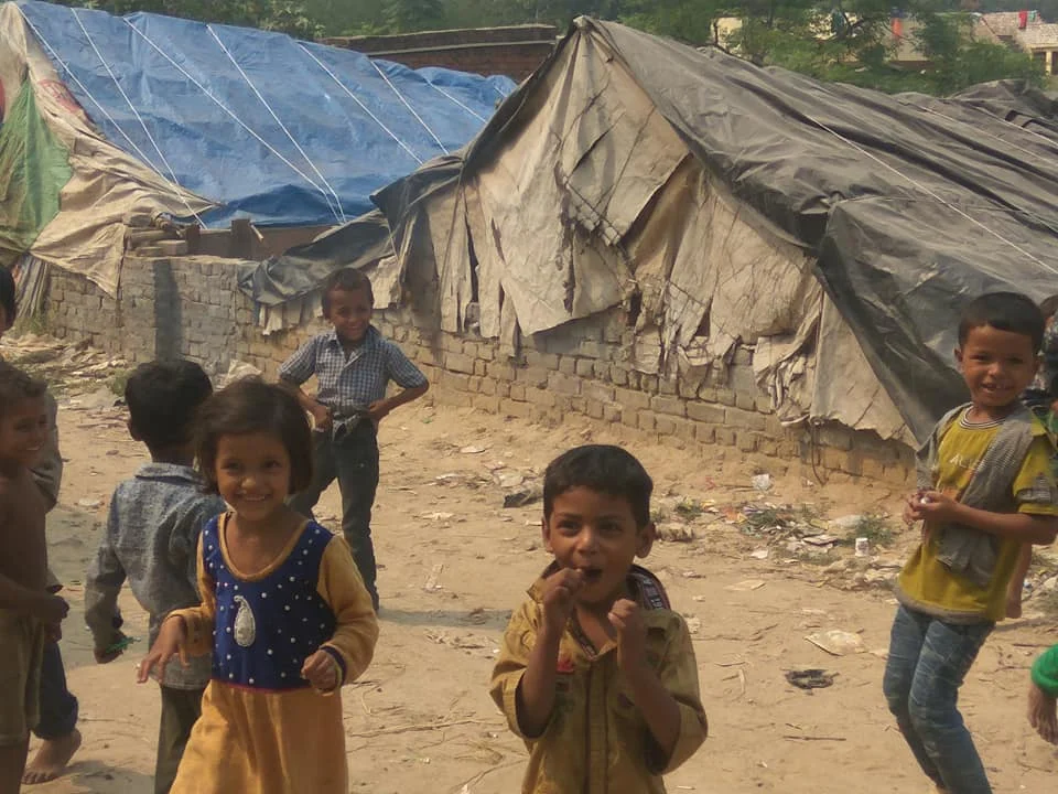 Children playing in front of makeshift shelters.