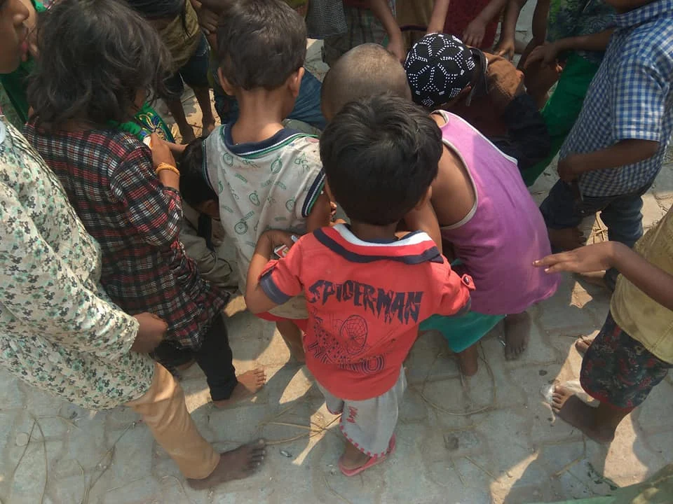 Children gathering outdoors in a circle.