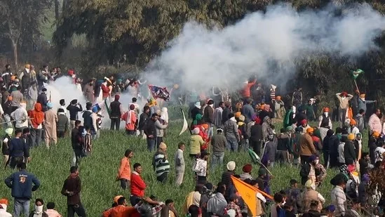 People at outdoor gathering with smoke and flags.