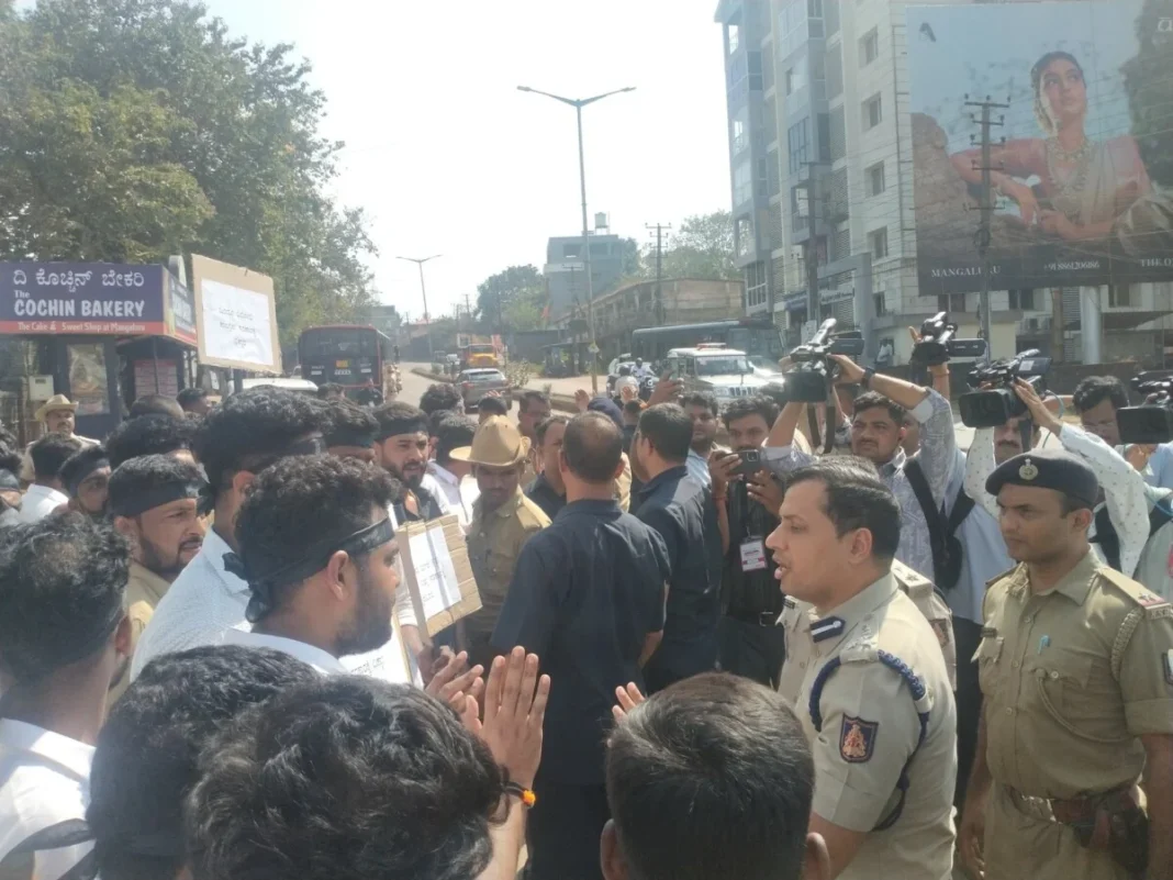 Crowd and police officers in discussion on a city street.