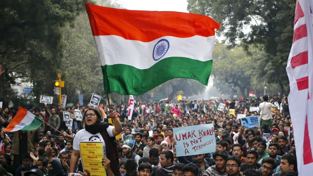 Protesters with Indian flags and signs at a rally.