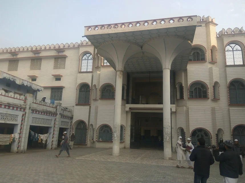 Traditional arched building entrance with people walking by.