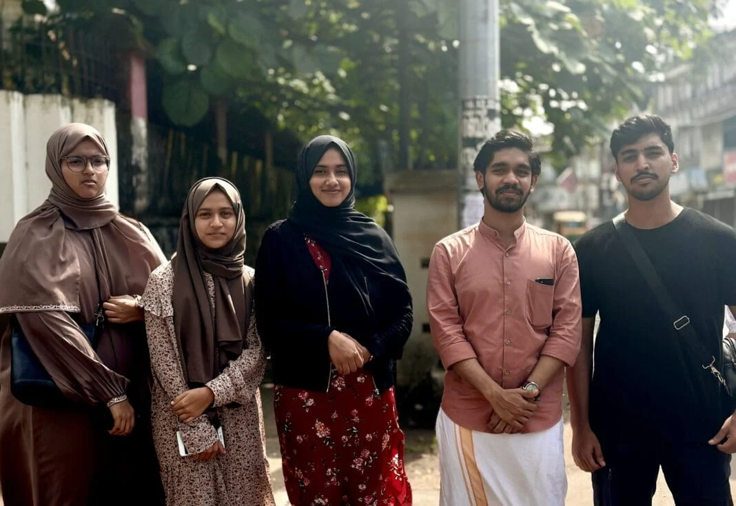 Group of five friends posing outdoors for a photo.