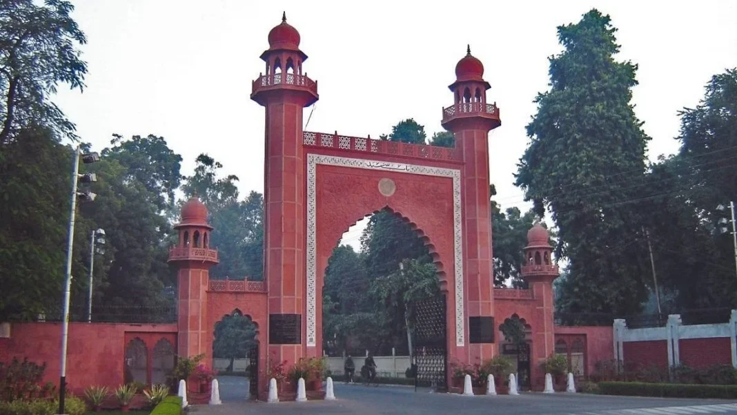 Red historical gate with twin towers and Arabic inscription.