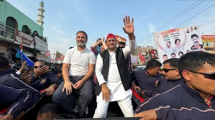 Political rally with waving participants on vehicle.